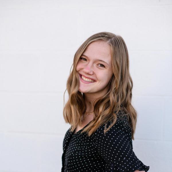 Emma Schneider stands in front of a wall.