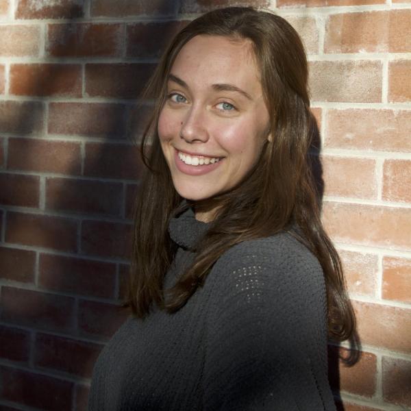Emma Seidler stands in front of a brick wall.