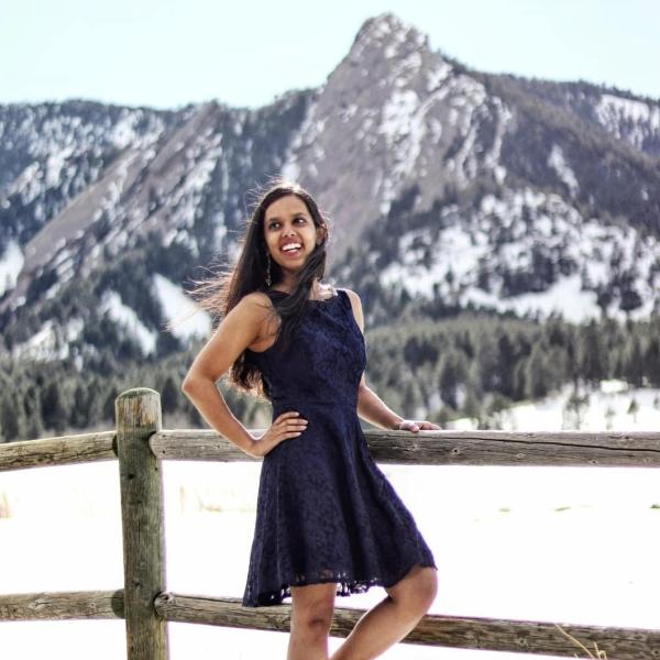 Anoushka Singh stands in front of a mountain.