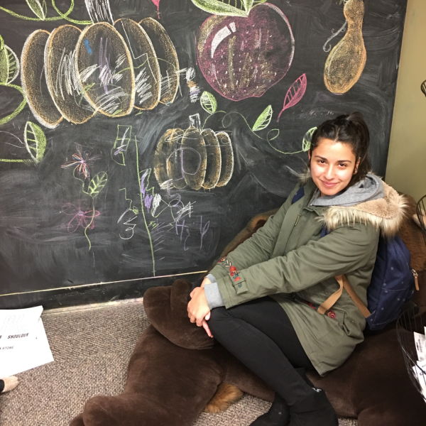 Camila Soffia Ramirez sits in front of a chalkboard.
