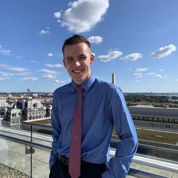 Cooper Thayer stands in front of buildings.