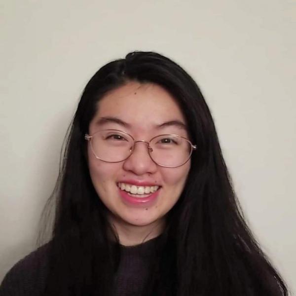 Ivy Vien stands in front of a wall.