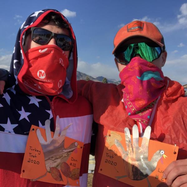 Daniel Wagner hugs an individual in front of a mountain.