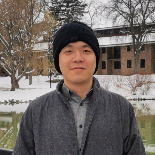 Chaoran Wang stands in front of a metal railing.