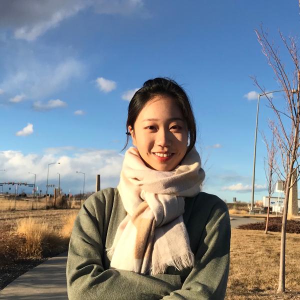 Jingyi Wu stands on a sidewalk.