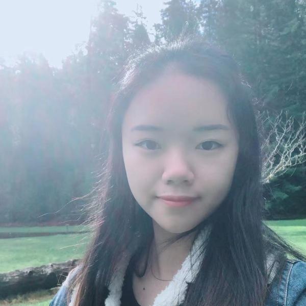 Qiucheng Xu stands in front of trees.