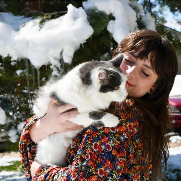 Kristin Zachman holds a cat in front of trees.