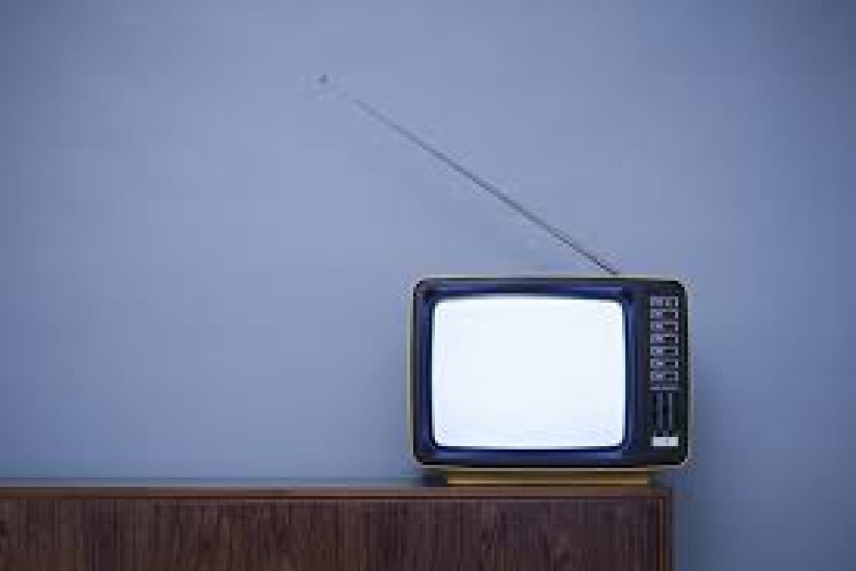 TV sitting on a table with blue background