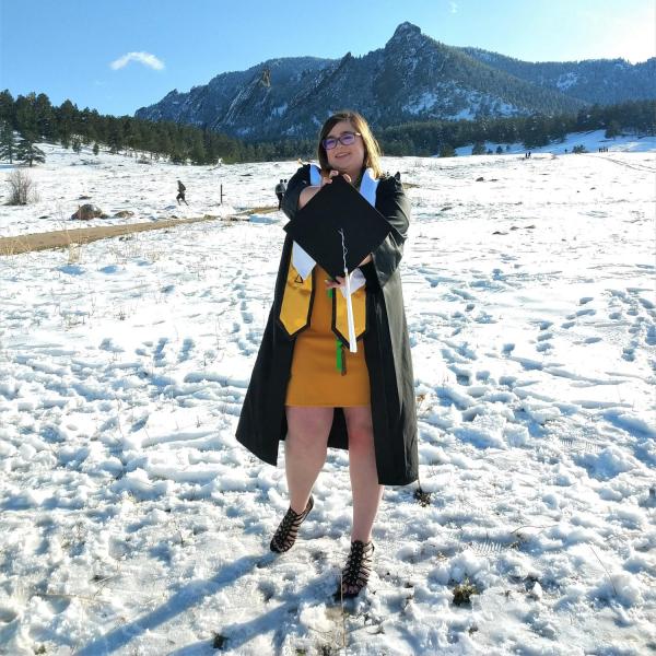 Kayleigh Cornell standing in snow with Boulder flatirons in the background