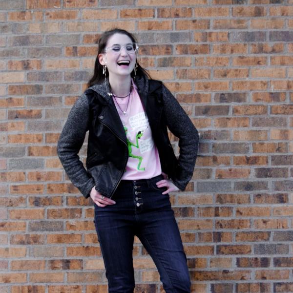 Madeline Pettine stands in front of brick wall.