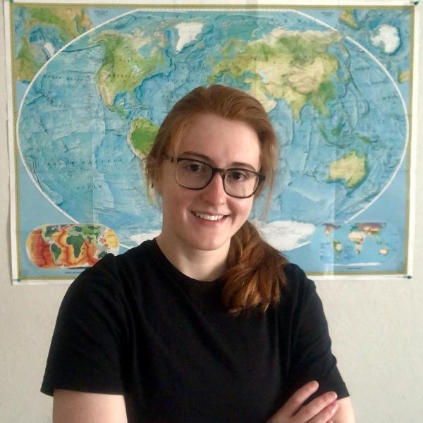 Madeline Schwarz stands in front of a map.