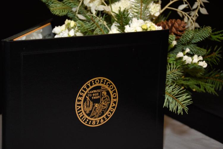 Certificate cover beside flower arrangement