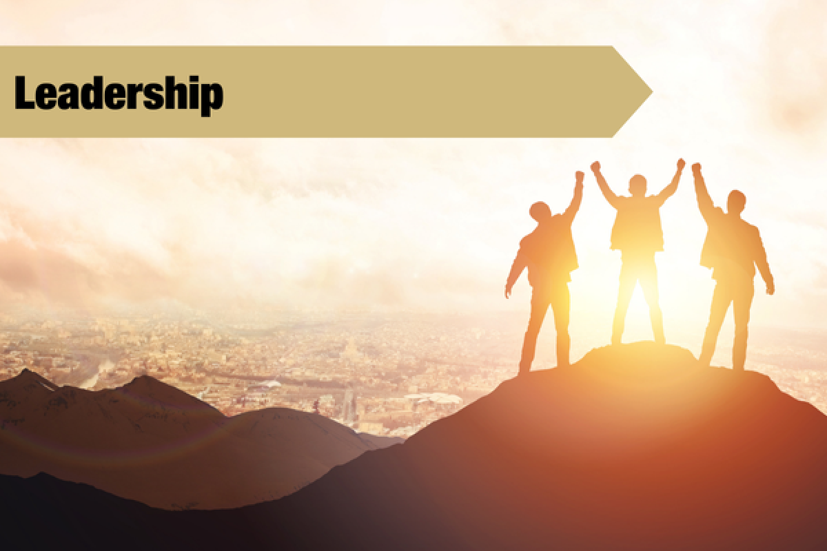 3 people standing at top of a mountain with leadership banner