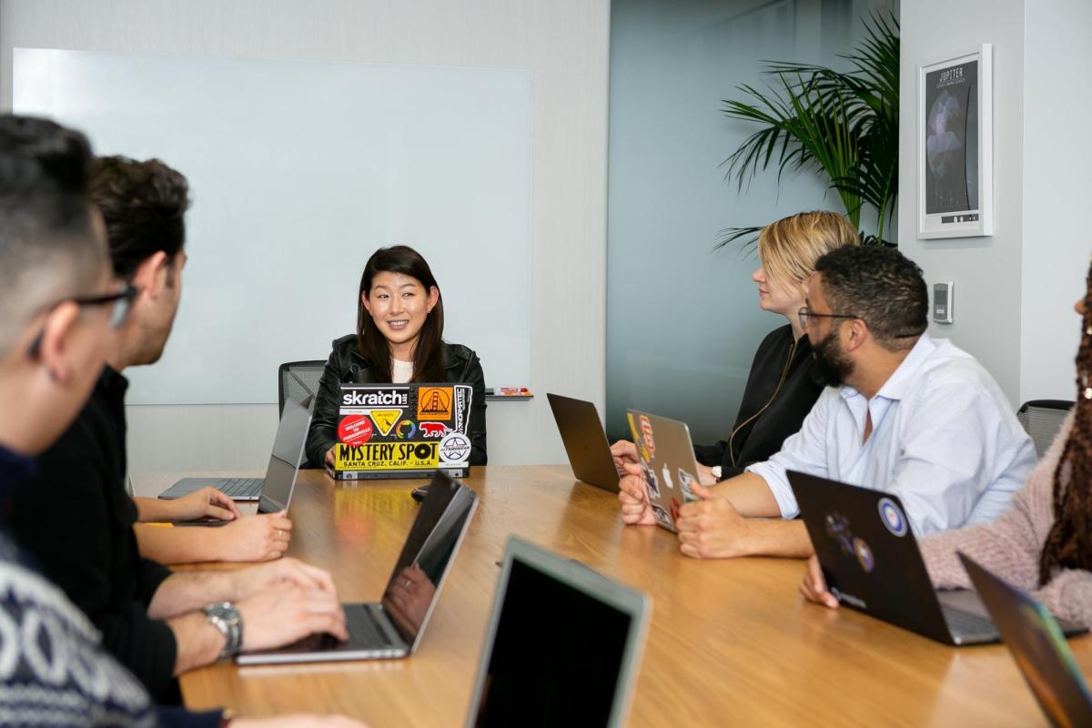 employees in an in-person meeting space with laptops