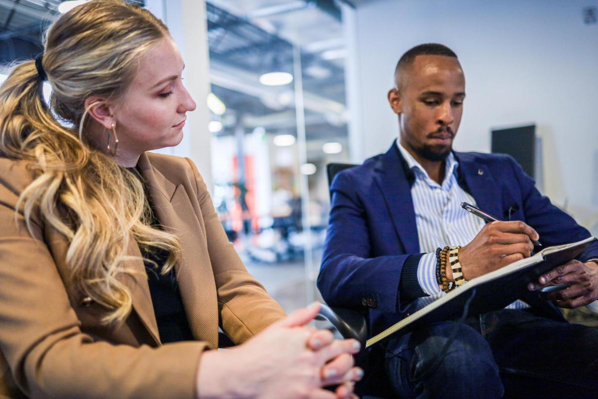 two people in an office looking at a tablet