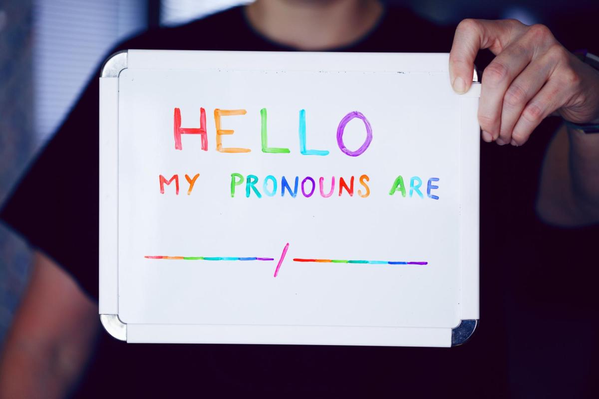 Small whiteboard with "Hello, my pronouns are __" written on it