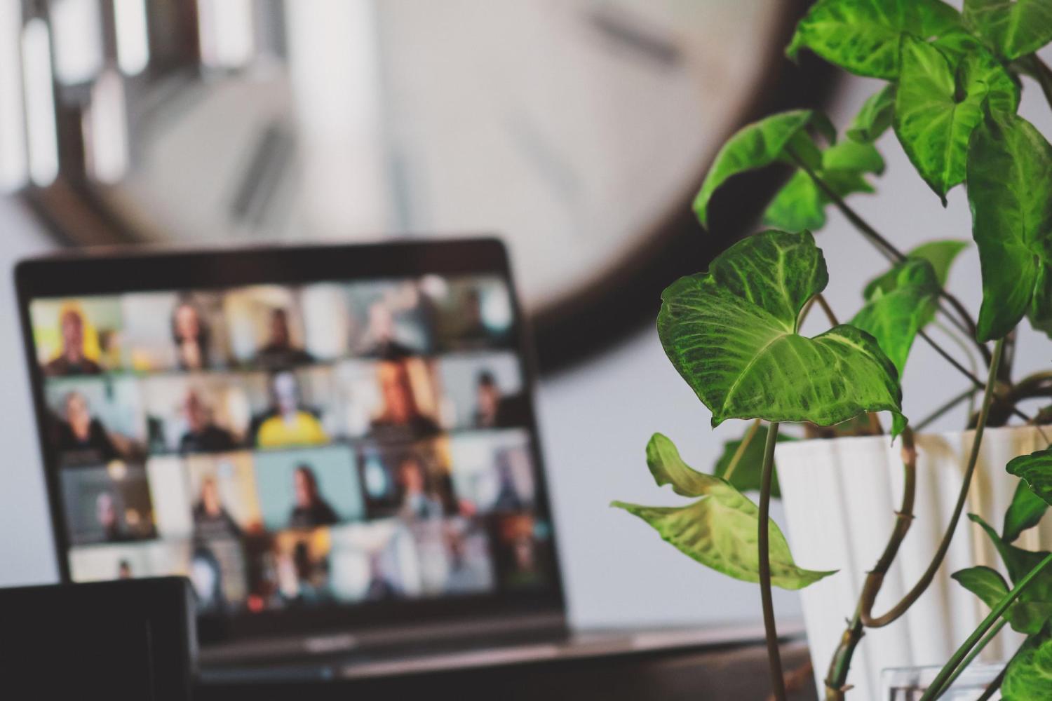 laptop with blurred images of people on zoom