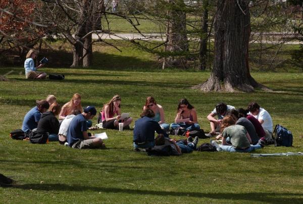 Photo of CU Students studying outside in the grass in a circle