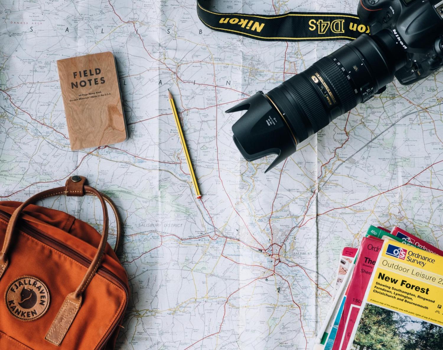 map with a camera, guide books, pencil, satchel.