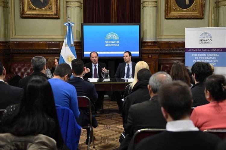 tom talking with a senator at argentine senate, in front of crowd