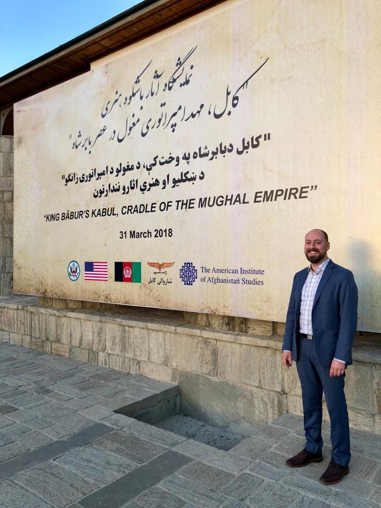 james souza standing next to the american institute of Afghanistan studies