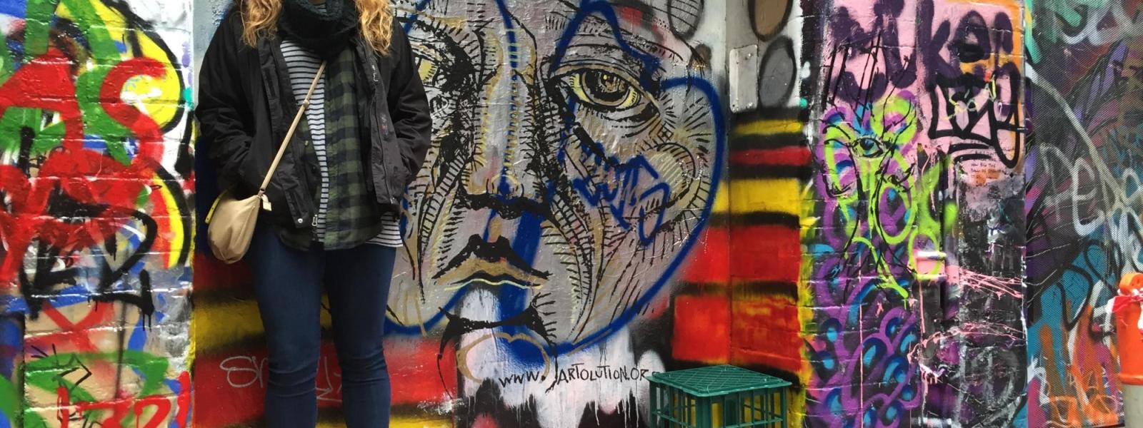 colleen standing among colorful grafitti art