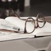 Pair of glasses on a book with writing