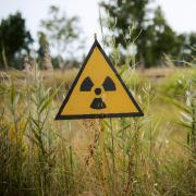 field of grain with a radioactive sign at Chernobyl Exclusion Zone, Ukraine