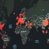 dark colored computer screen with map of the world with red dots on it showing the extent of covid-19 outbreaks
