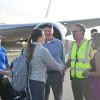 group of people standing in front of an airplane