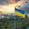 a Ukrainian flag-on-a-pole-with-a-city-in-the-background