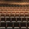 Rows of empty brown seats in an auditorium