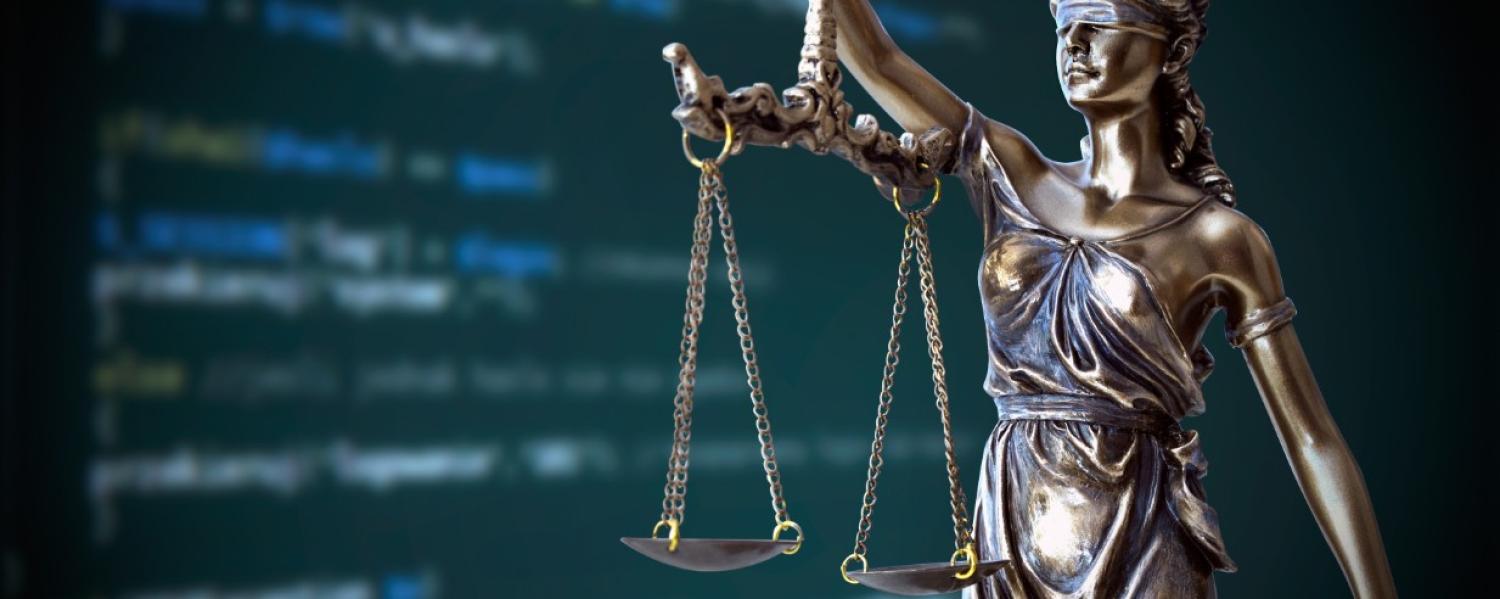 image of computer code alongside a statue of Lady Justice