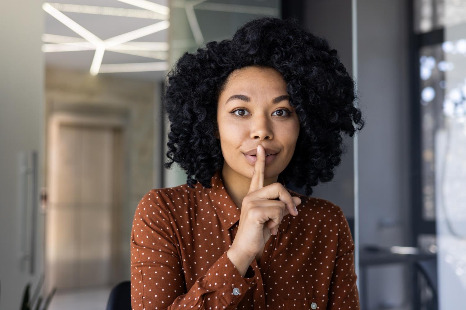 Black woman finger over mouth
