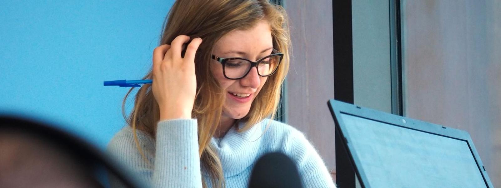 student works at her computer while being filmed