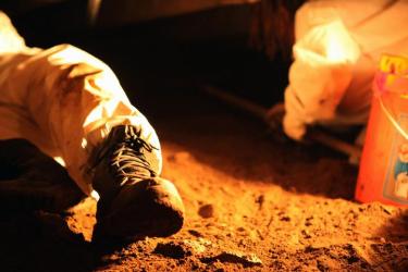 The boot of AmeriCorps volunteer Alex Yung rests on packed river silt that fills the basement of Lyons resident Candace Shepherd. (Annie Melton/CU News Corps)