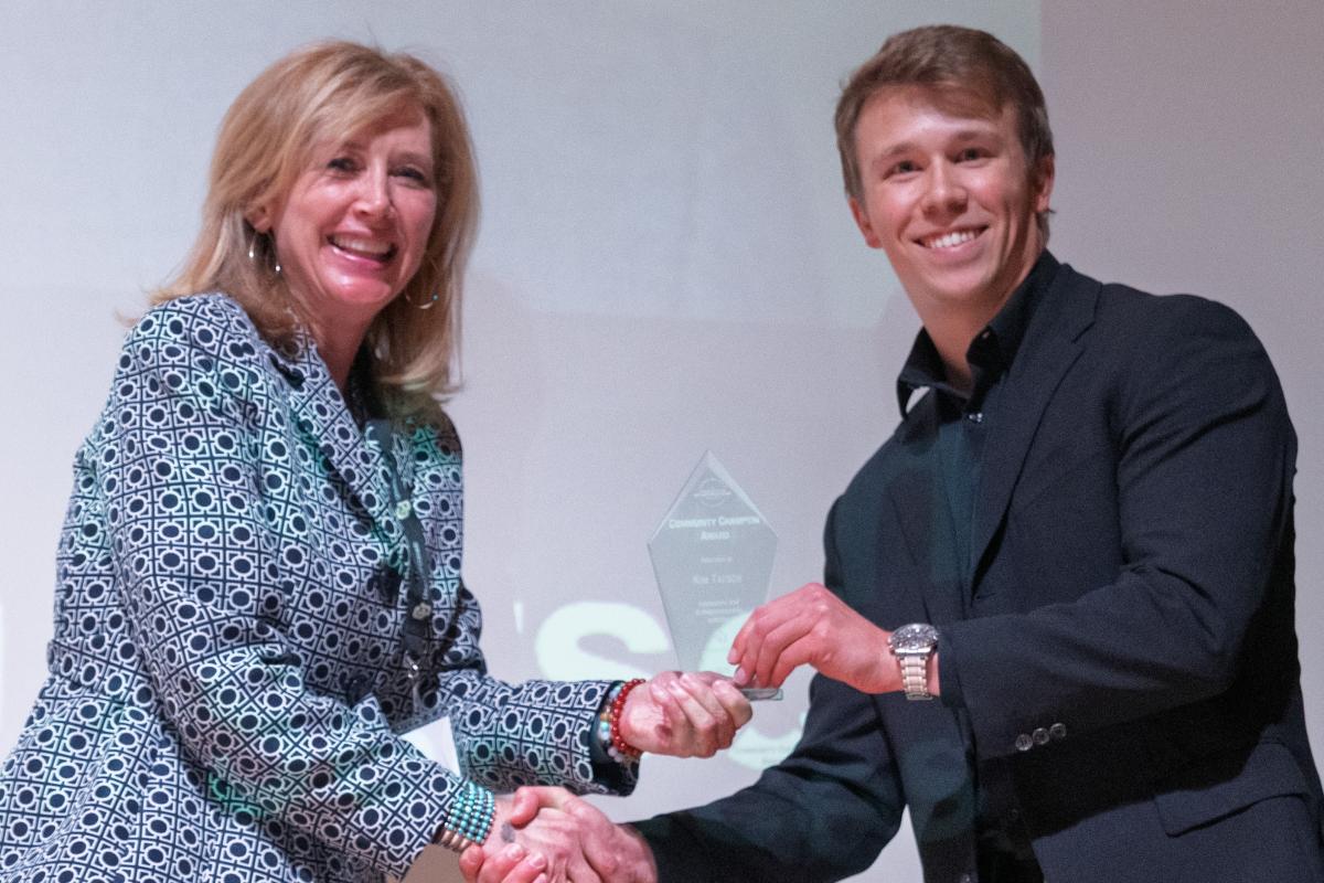 Kim Tatsch receives the Community Champion Award from Harris Cunningham
