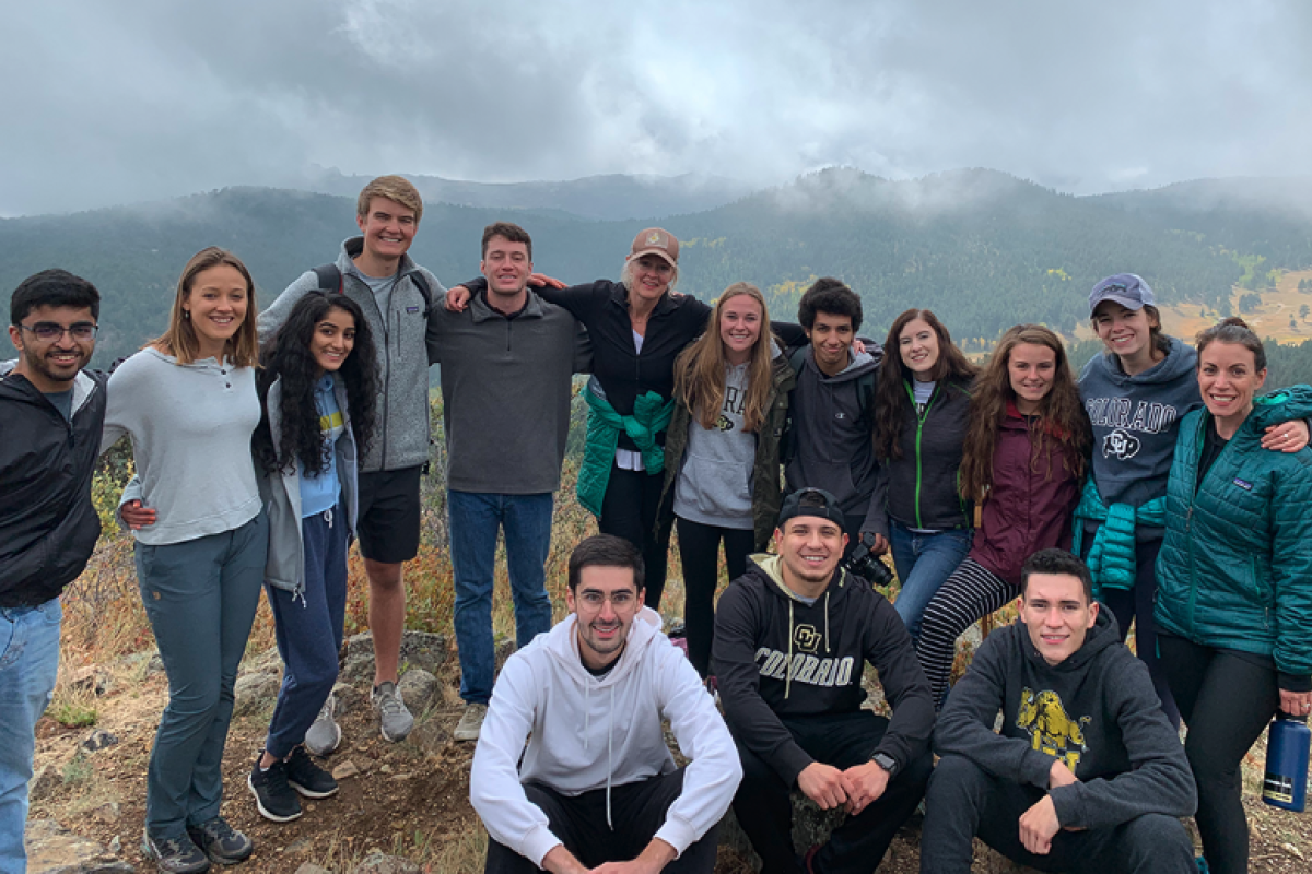 Group of friends takes a picture at the top of a mountain