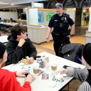 cu boulder police officer stops to talk to students in the UMC