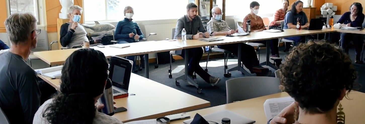 Photo of multiple directorate members gathered around several tables during a meeting