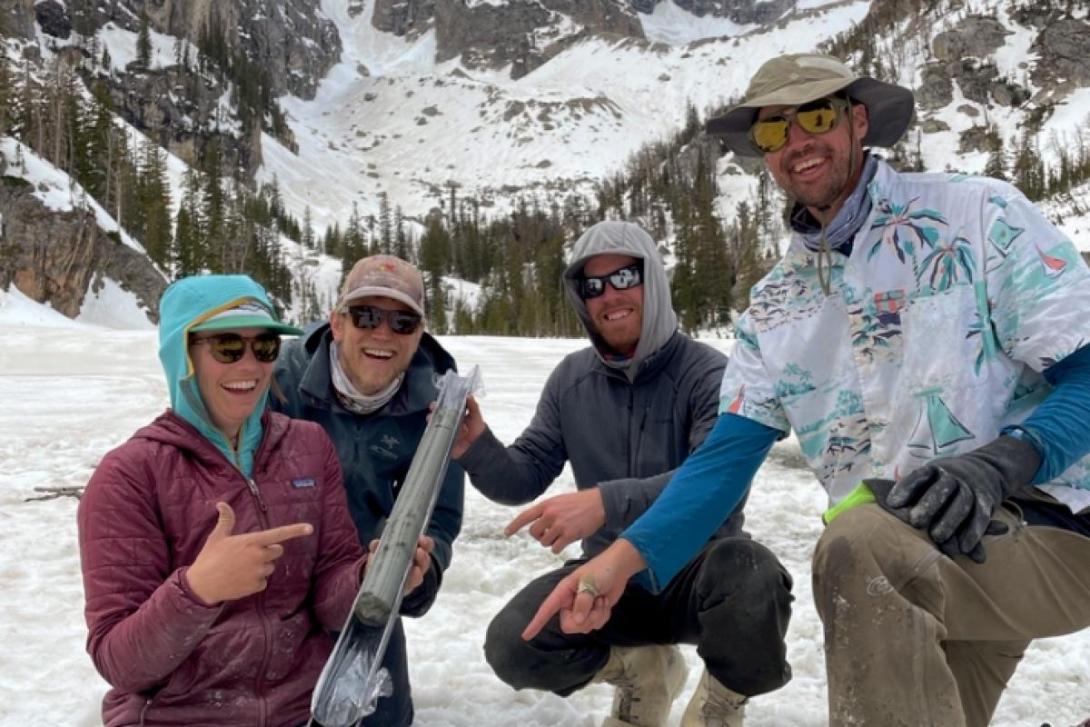 Sarah Crump, Jonathan Raberg, Darren Larsen, and name TBA show off a newly extracted sediment core from an ice-covered lake in the Grand Tetons
