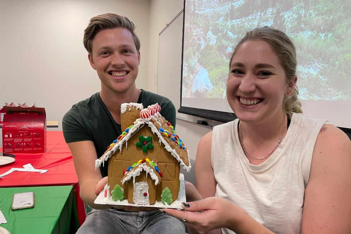 Two people at the JEDI social event work on their gingerbread houses