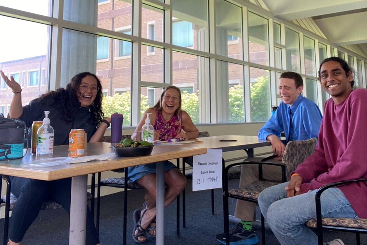 Four participants of the Spanish Language Lunch Table share a laugh