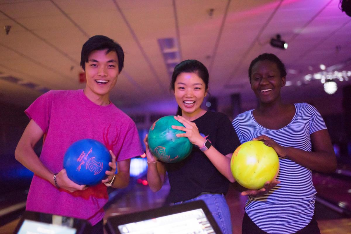 Three diverse people bowling