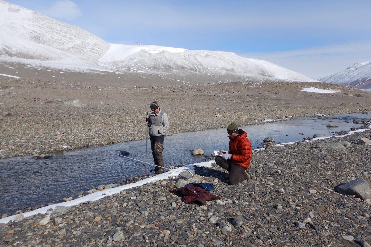 Several researchers measure streamflow in Antarctica