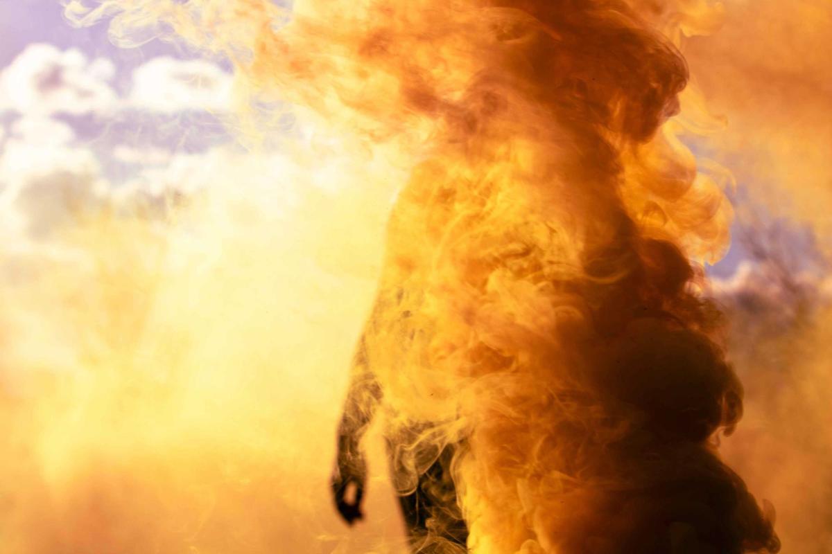 Bright orange colored air surrounds a person. Experimental photography by Kelsey Simpkins