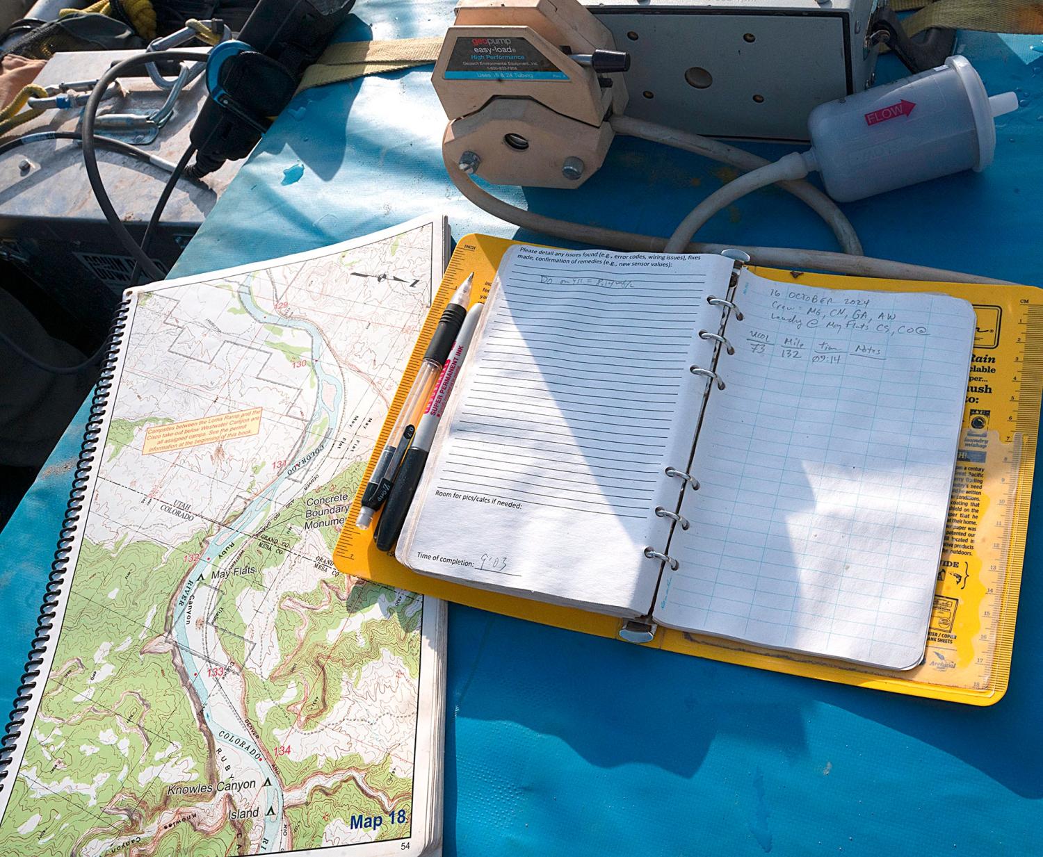 A map of the Colorado River and a waterproof notebook for logging data lay on a cooler atop a large raft used for surveying water quality of the upper Colorado River