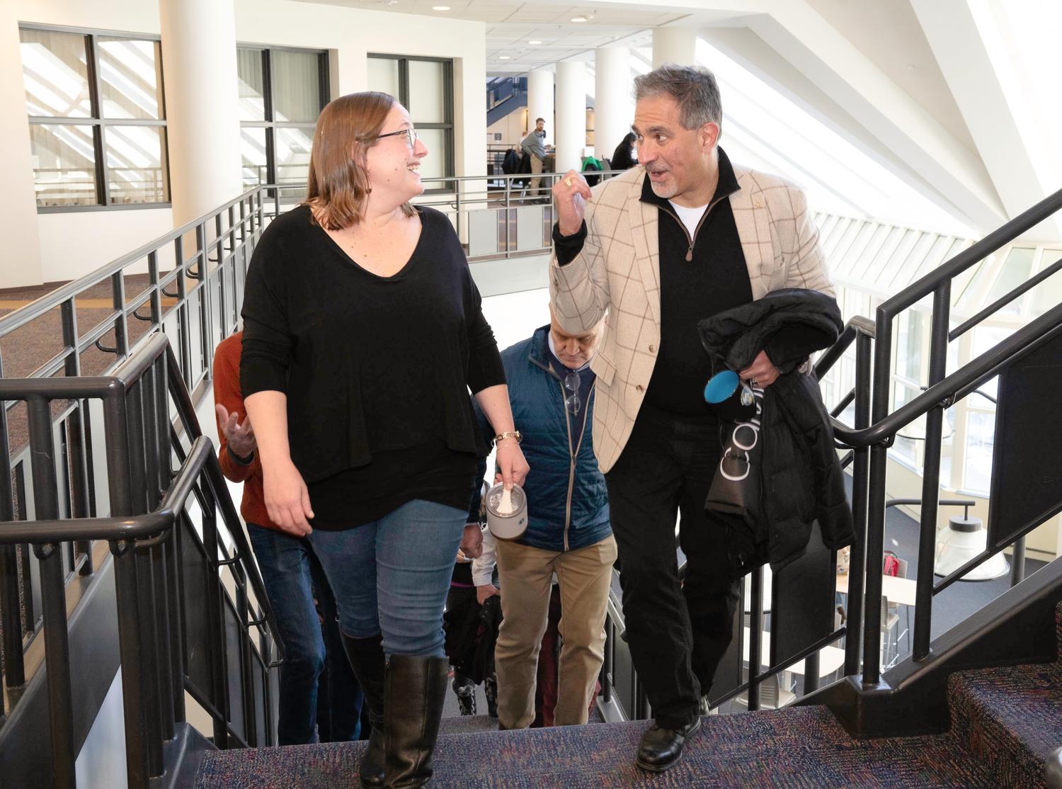 A group of people walk up a staircase directly toward the viewer