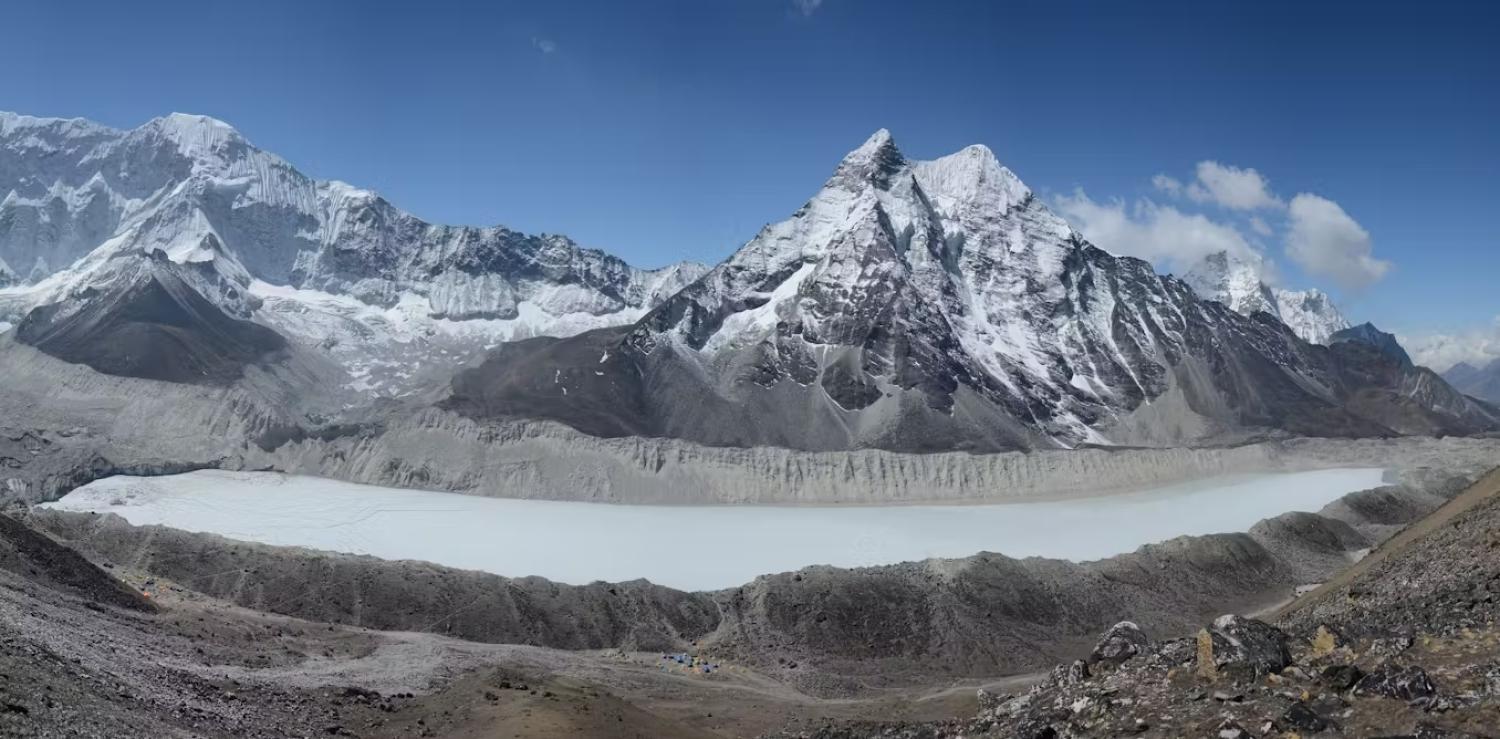 snow-covered mountains above a sunny alpine lake