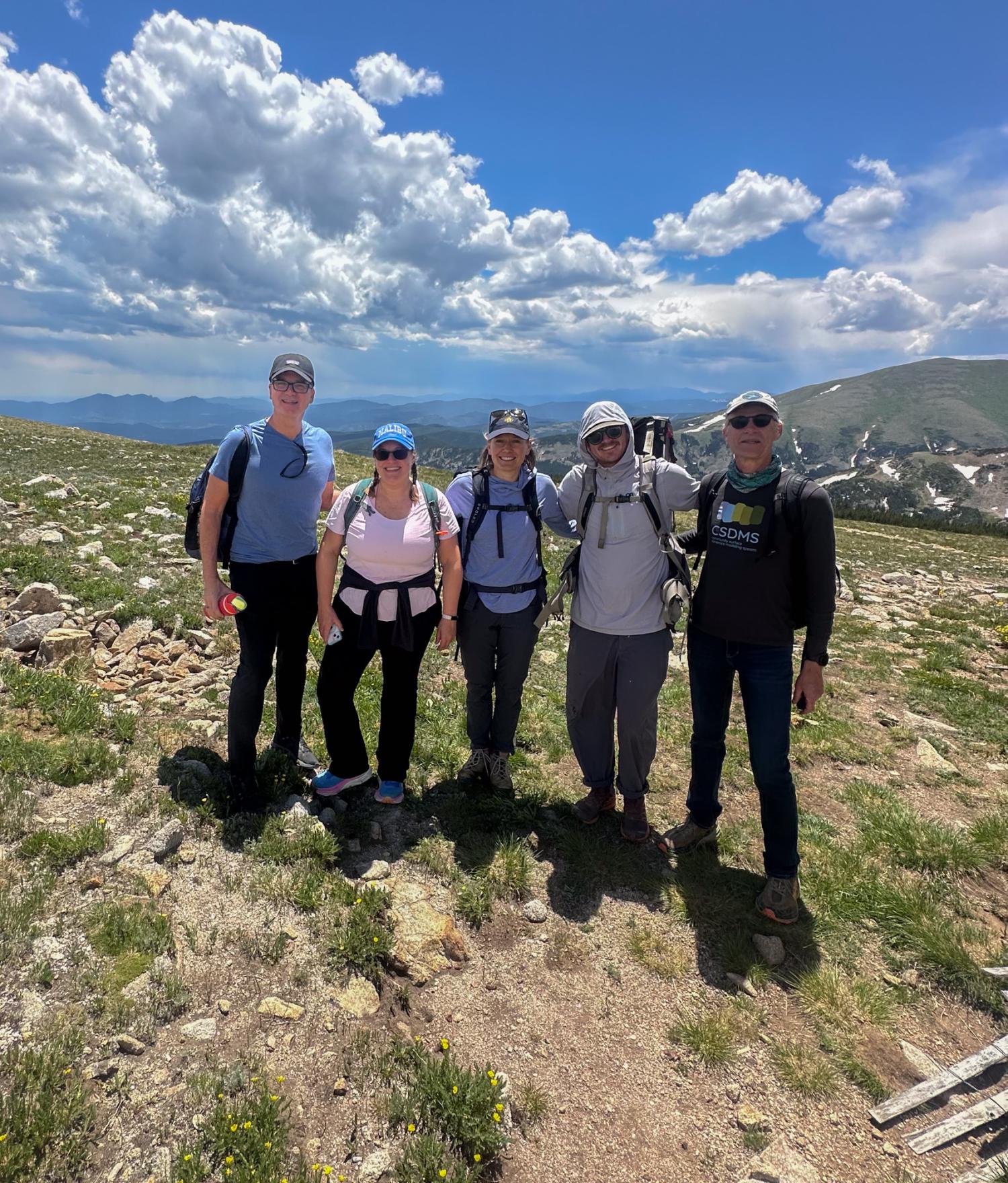 A group of people pose for a photo in the mountains